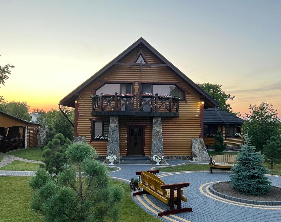 波恰耶夫Rodynne Gnizdo的小木屋设有阳台和长凳