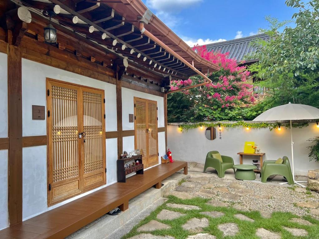全州市Pungnam House的庭院配有桌椅和遮阳伞。