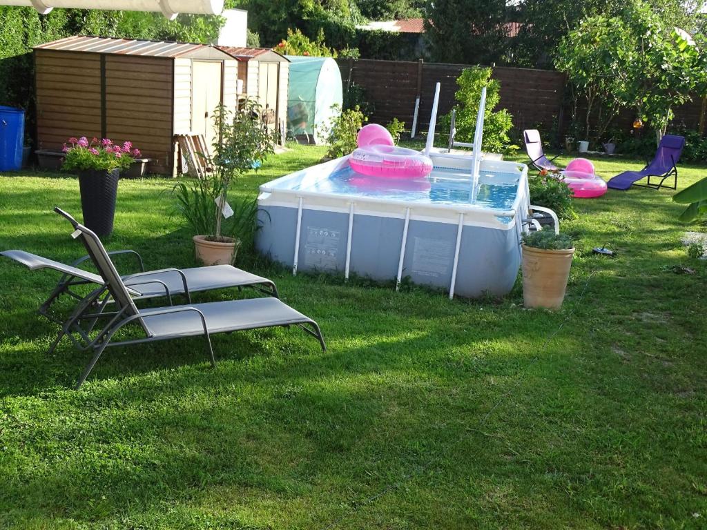 索容LA DATCHA的庭院内的游泳池,配有两把椅子和一张桌子