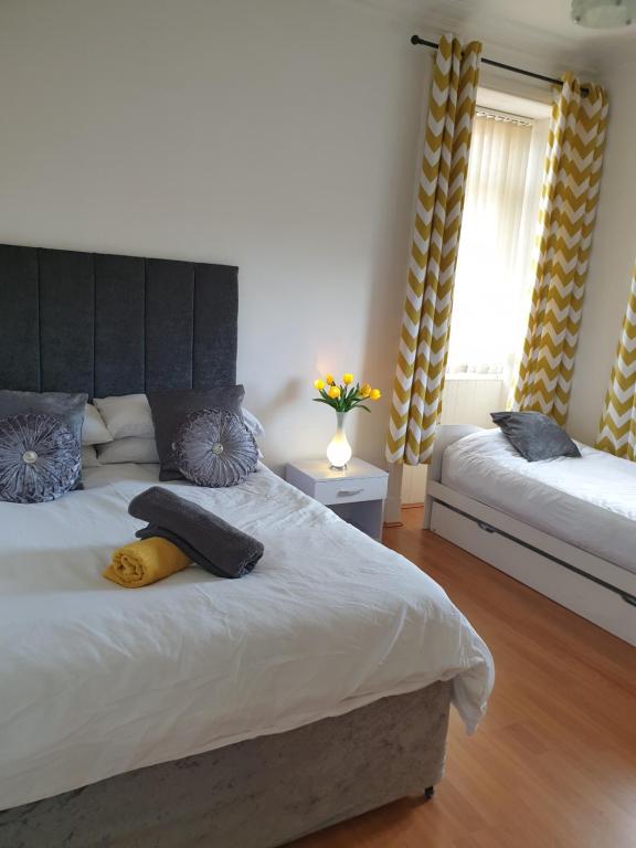 特伦Troon Beach Town Golf Apartment Troon Ayrshire的一间卧室设有两张床和窗户。