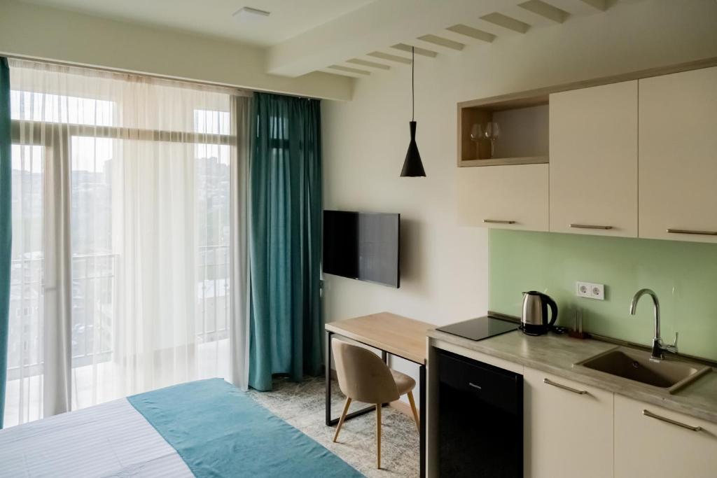 埃里温Rooftop Apart-Hotel的一间设有床铺、厨房和桌子的房间