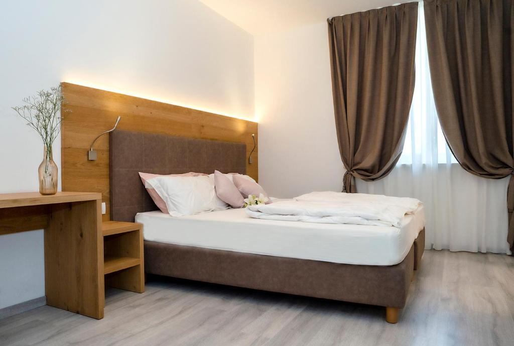 DennoDal Pez的一间卧室配有一张带木制床头板的床
