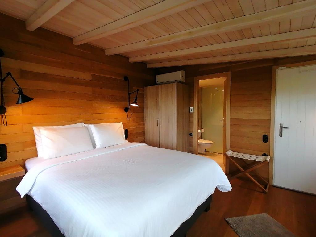 Paltsi PilionK Lux Apartments的一张白色大床,位于带木墙的房间