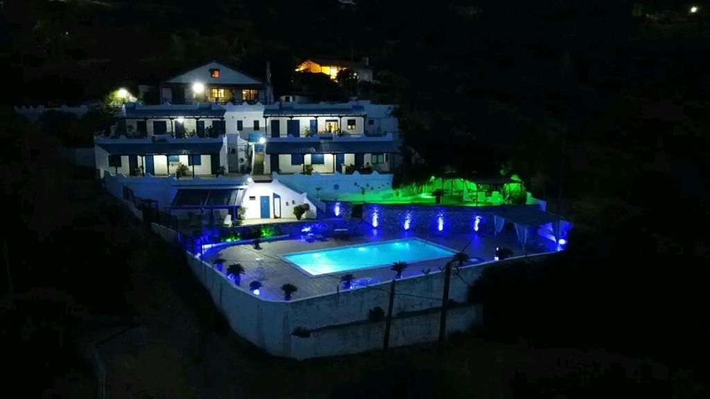 Akhladherí阿夫拉公寓式酒店的一座在晚上设有游泳池的大房子