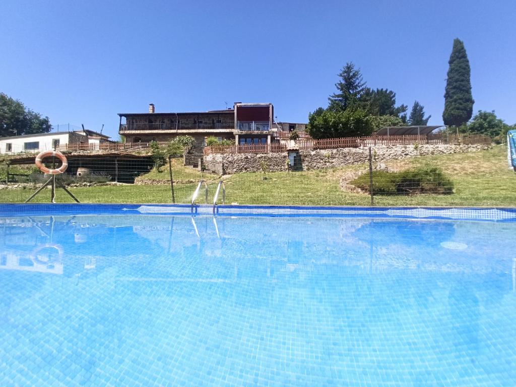 潘通Casa dos Muros turismo rural y actividades en la Ribeira Sacra的一座大型游泳池,后面有一座房子