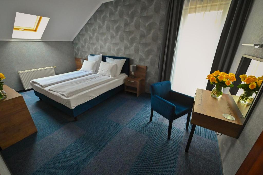 格鲁德柴兹拉德酒店的卧室配有1张床、1张桌子和1把椅子