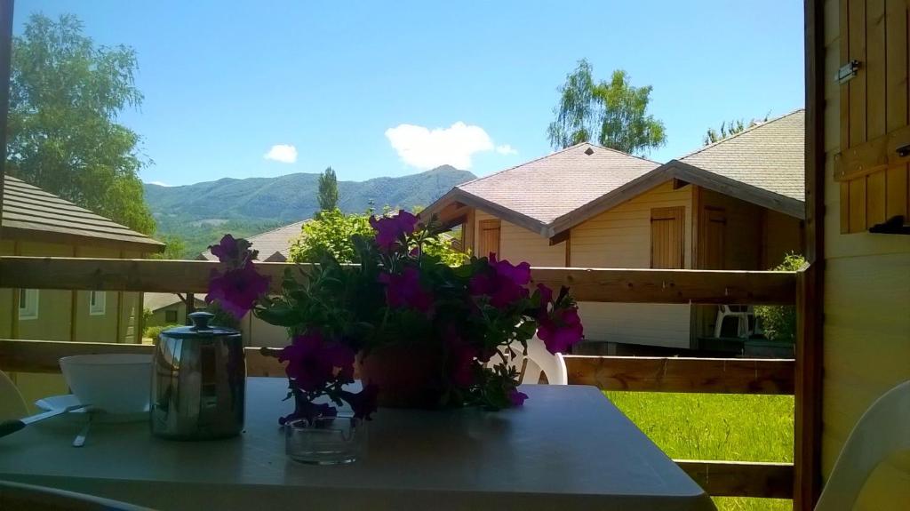 SoueixVillage de Vacances Les 4 Chemins的阳台顶部一张带紫色花的桌子
