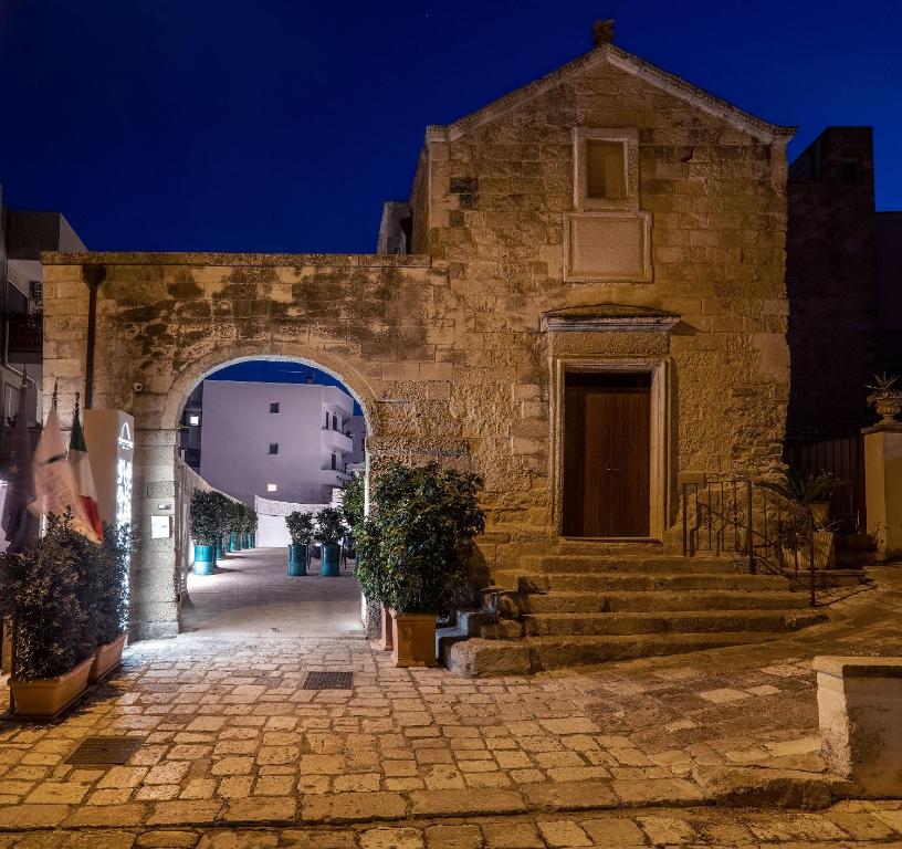 奥特朗托Dimora San Giuseppe Hotel & SPA的一座带拱门的古老石头建筑的入口