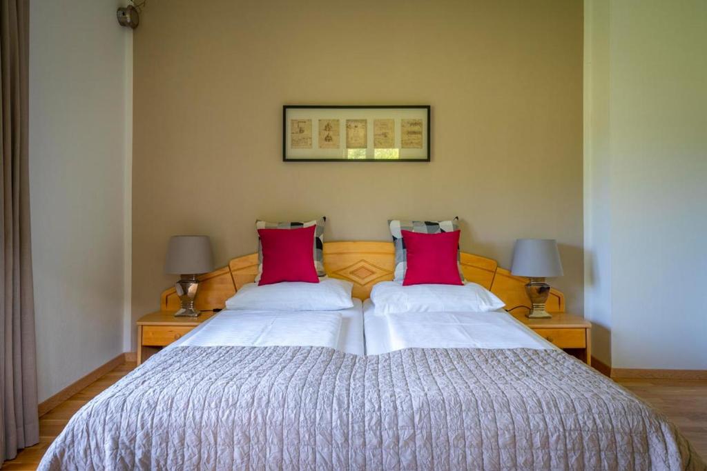 奥西阿赫Pension Strauß的一间卧室配有一张大床和两个红色枕头