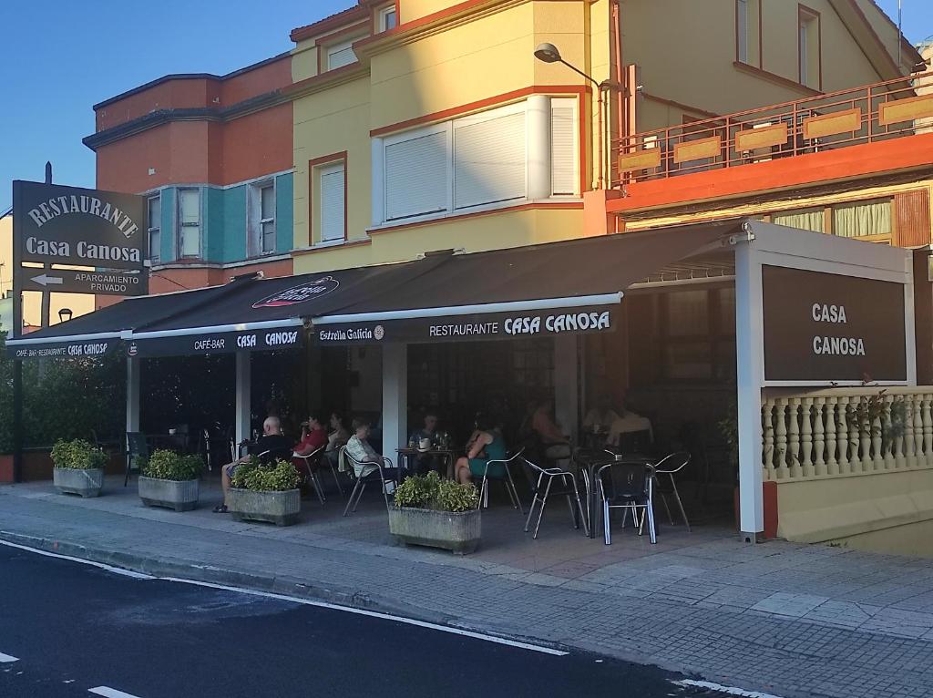 拉科鲁尼亚Casa Canosa的城市街道上一家带桌椅的餐厅