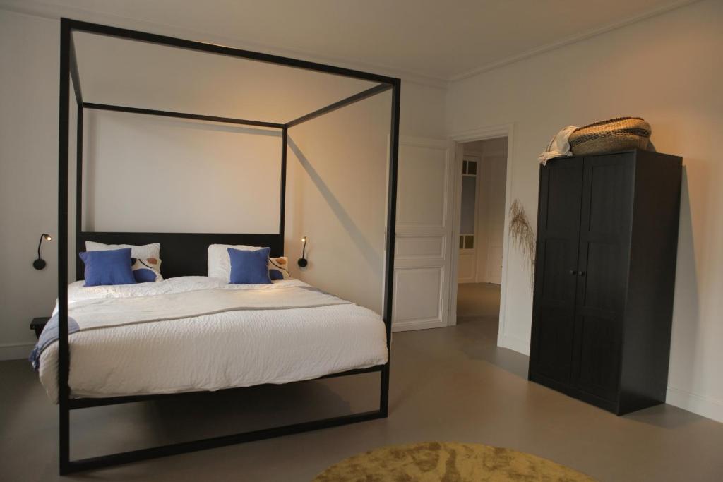根特MAISON KITOKO的一间卧室配有一张带蓝色枕头的天蓬床