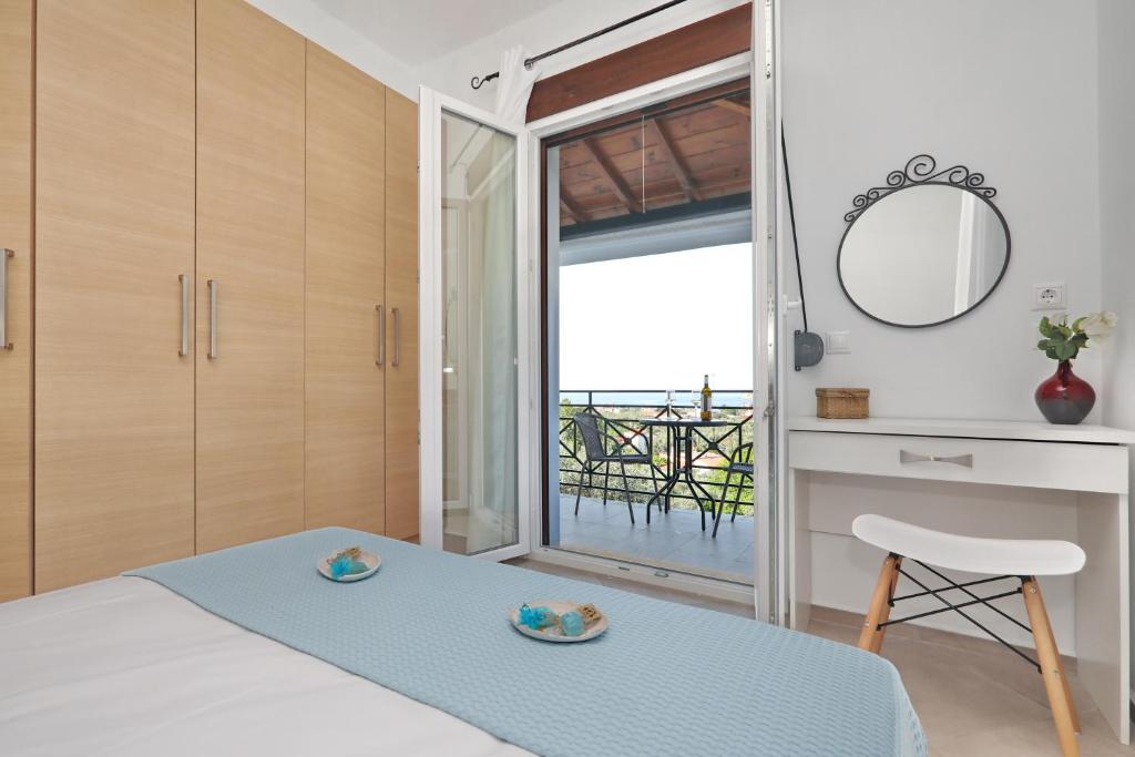 斯科派洛斯Esperides Apartments Aigli的一间卧室配有一张床、镜子和一张桌子