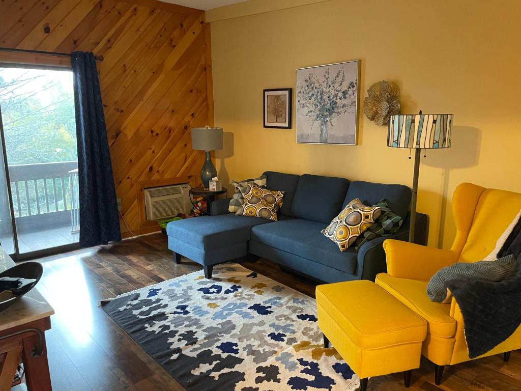 拉科尼亚Village at Winnipesaukee 59 Treetop #432的客厅配有蓝色的沙发和黄色的椅子