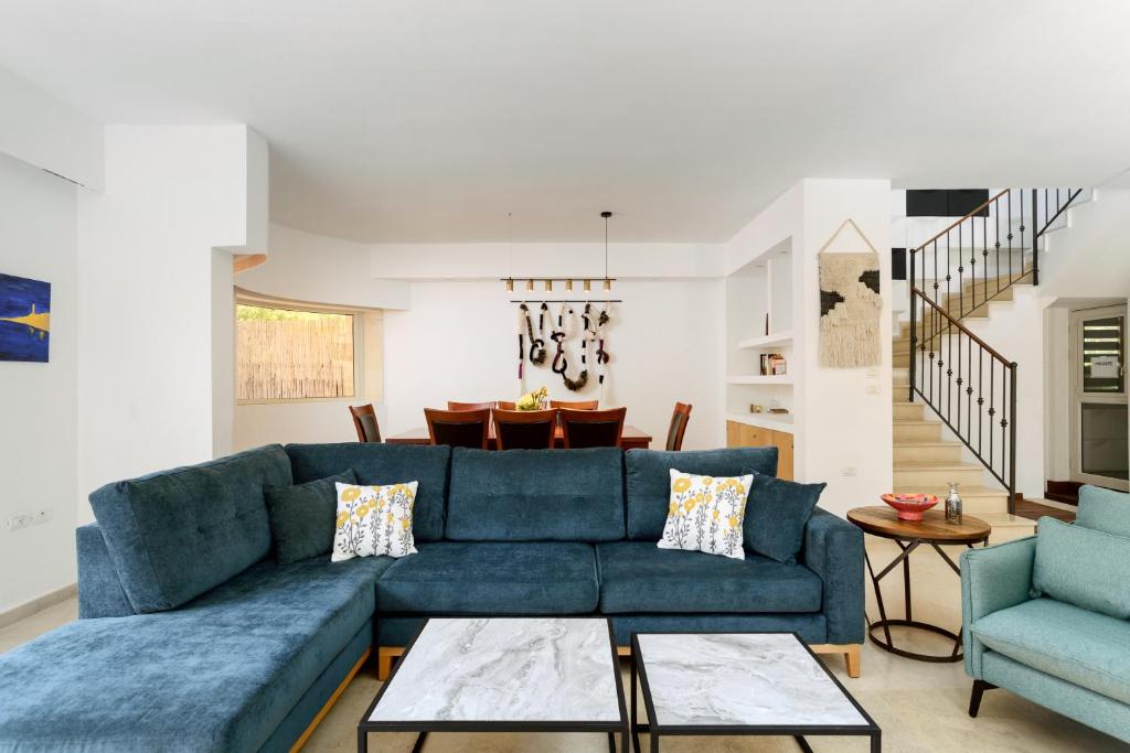 内坦亚Luxury Villa, Terrace with SEA VIEW in the center的客厅配有蓝色的沙发和两把椅子