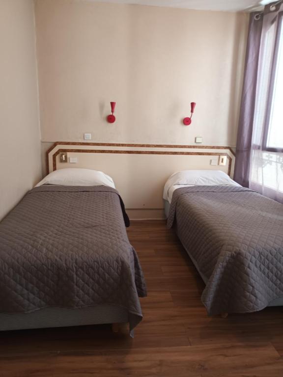 巴黎罗莱纳酒店的卧室内两张并排的床