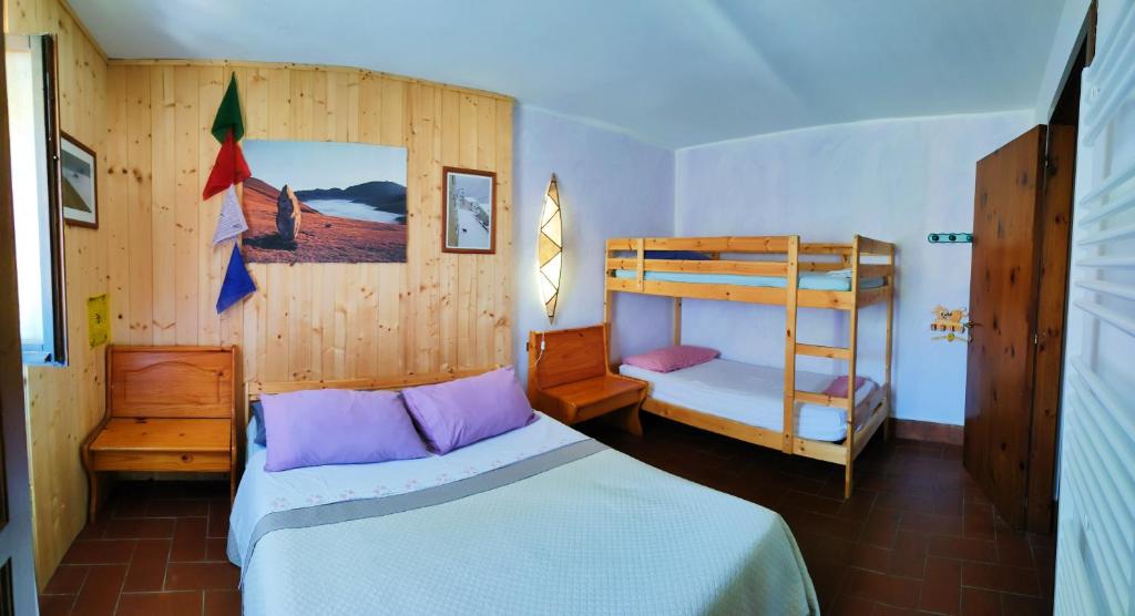真加B&B Bivacco Frasassi climbing & trail running house的一间卧室配有两张床和一张双层床。