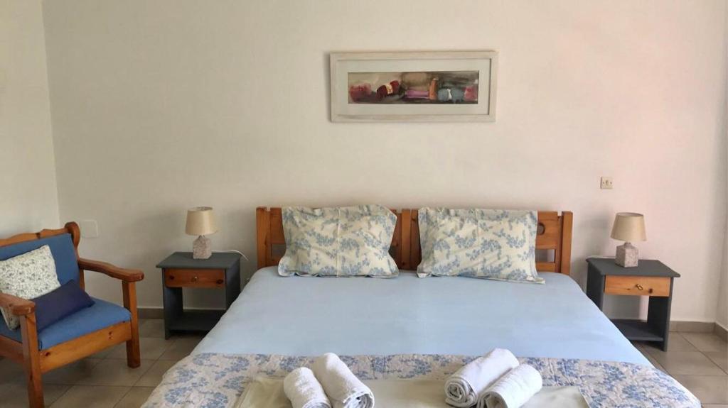 阿尔戈斯托利翁Barbara's one bedroom apartments的一间卧室配有一张床和一张蓝色椅子