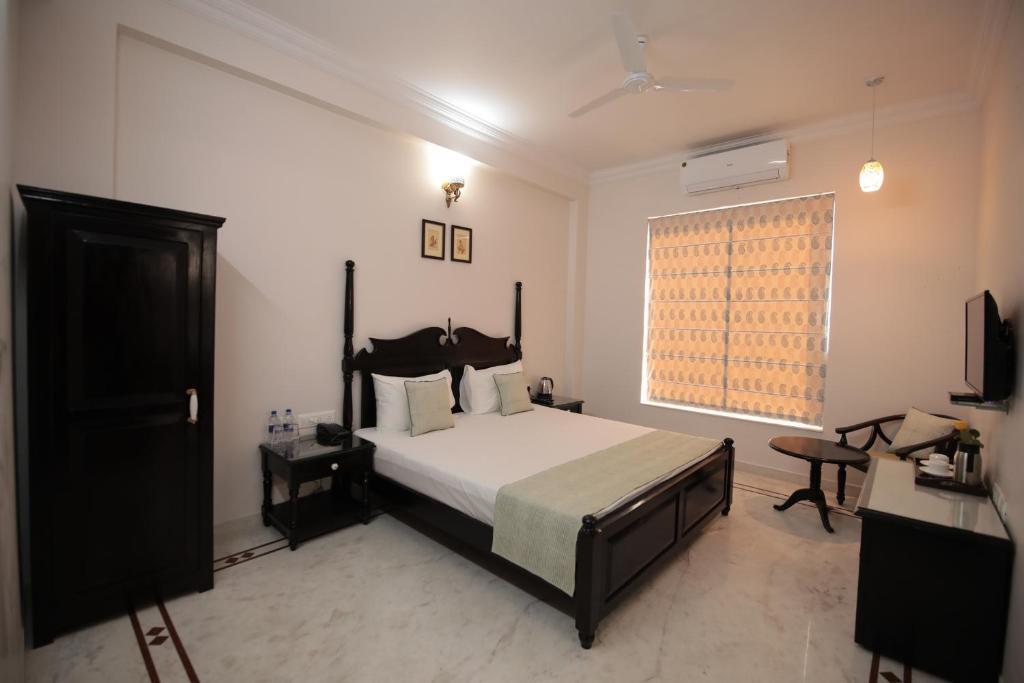 斋浦尔Jai Villa - A Boutique Hotel的一间卧室设有一张床和一个窗口