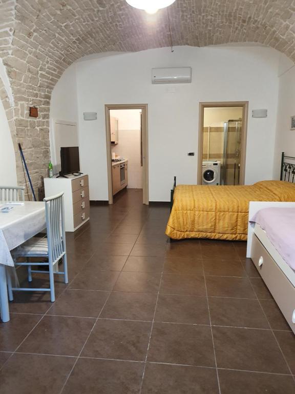 鲁沃迪普利亚La Casa In Fiore的大房间设有两张床、一张桌子和厨房