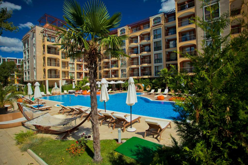 阳光海滩Harmony Suites 2,3的一个带吊床和棕榈树的度假游泳池