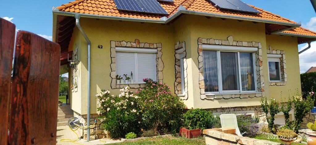 陶波尔曹Barackos Apartman的屋顶上设有太阳能电池板的黄色小房子