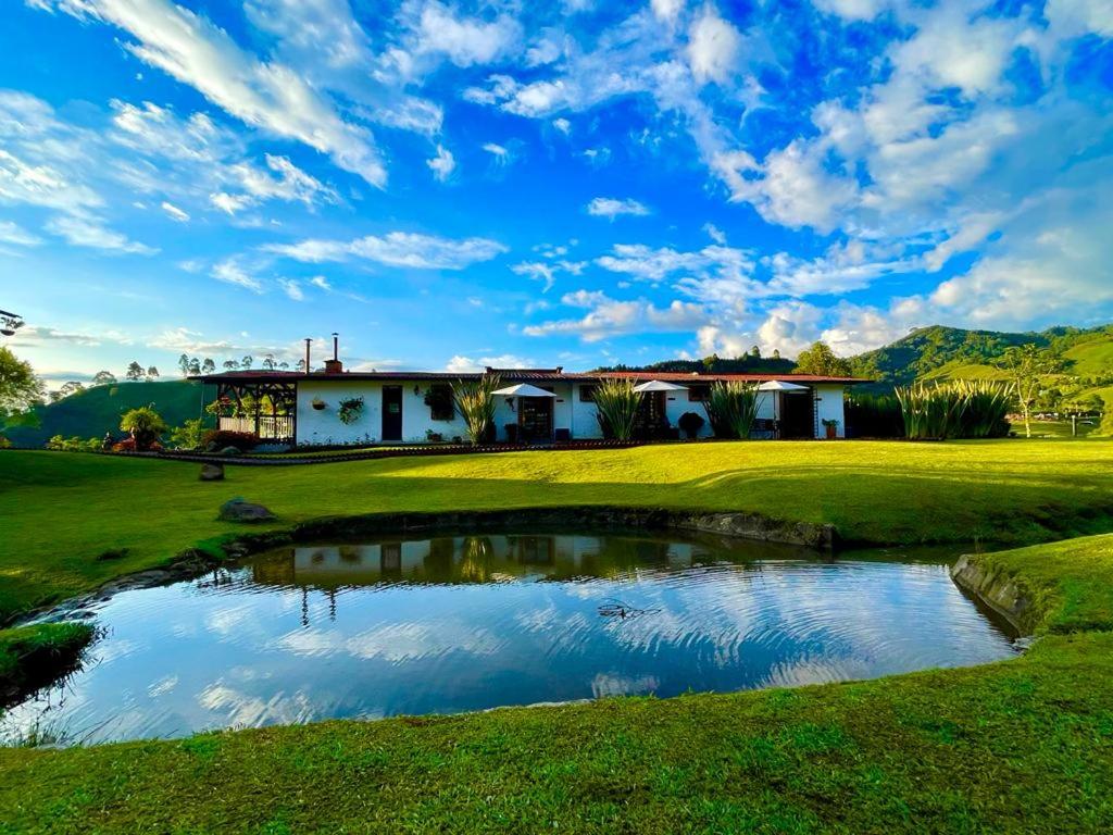 圣罗莎德卡瓦尔Cabanas La Herradura的一座高尔夫球场,房子前面有一个池塘