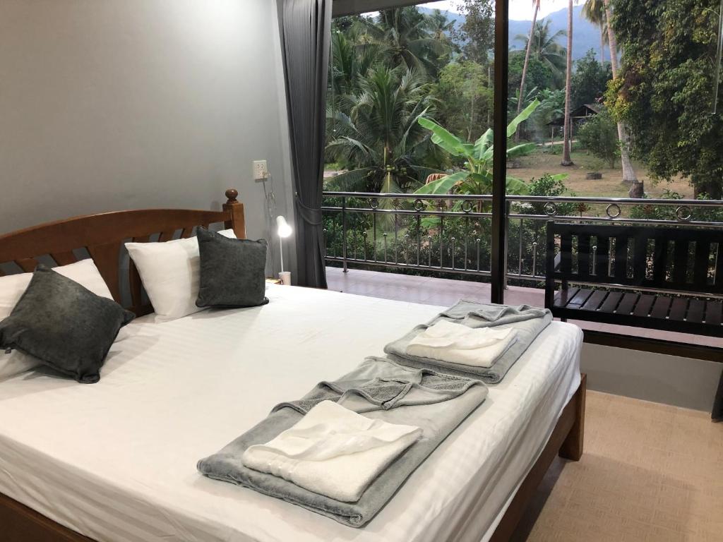 班泰Yangyai Garden Lodge的一间卧室设有两张床和大窗户