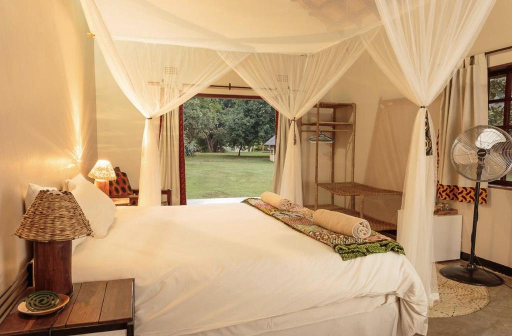 MfuweMarula Lodge的卧室配有白色的床和窗户。