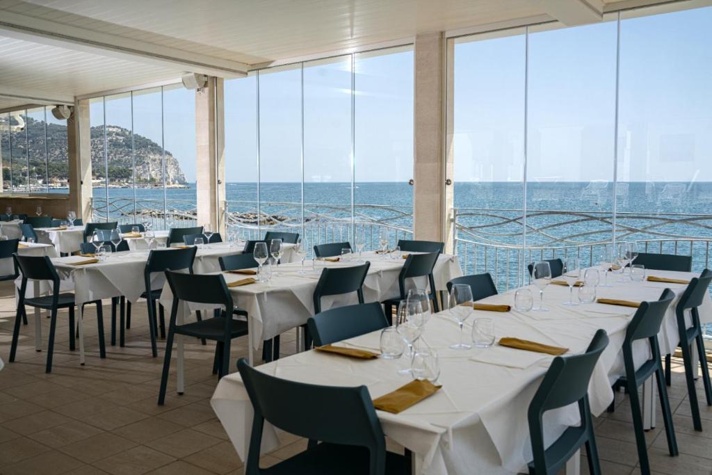 马蒂纳塔Residence Adriatico的一间设有白色桌椅的海洋餐厅