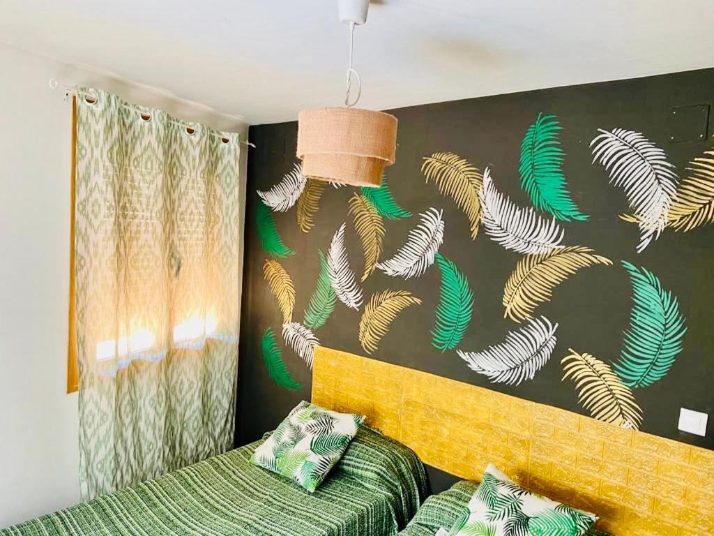 阿罗约弗里奥El Río的一间卧室设有绿色的床和一堵带鱼类图案的墙壁