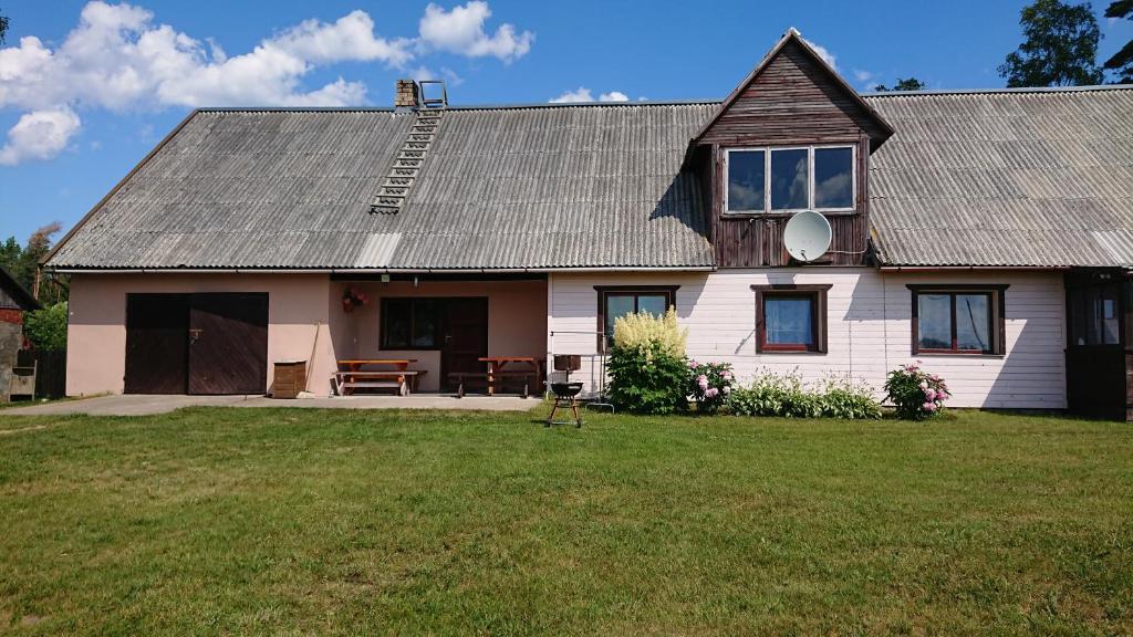 尤卡尔内Dzīvoklis Pirmie Zaļmeži的白色的房子,有灰色的屋顶和院子
