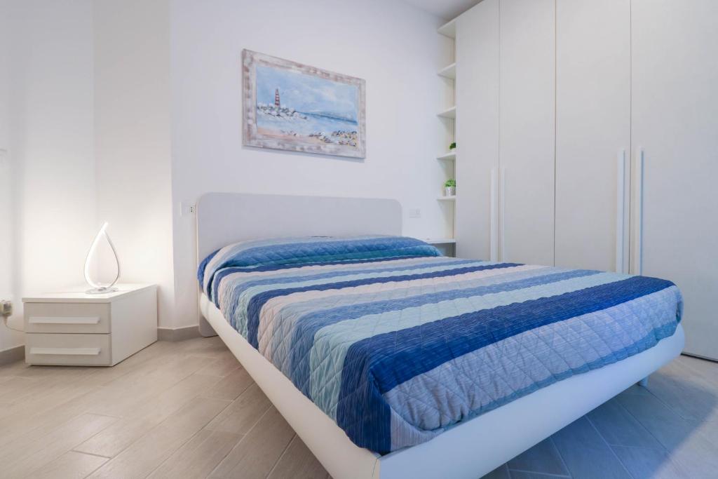 圣托·斯特凡诺·阿尔马尔H11 LUXURY 3B - Porto - Piscina - Jacuzzi的白色卧室配有一张带蓝色毯子的床