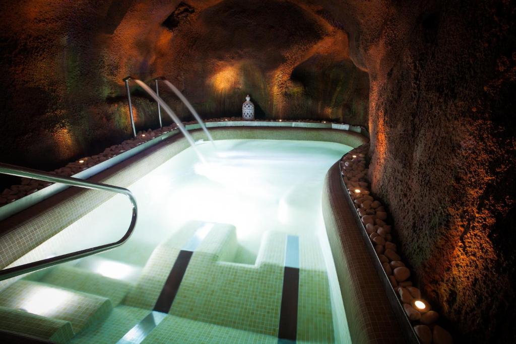 钦琼拉格拉亚乡村旅馆及Spa的洞穴内的热水浴池,铺有绿色瓷砖