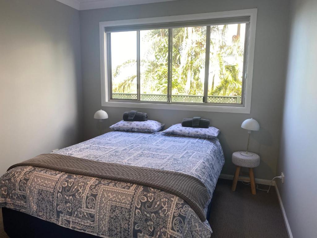 科夫斯港Central Oasis的一间卧室设有一张大床和大窗户