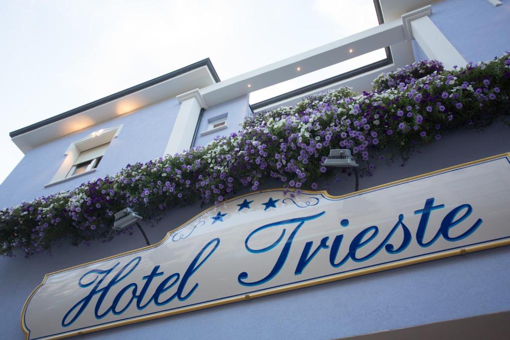 切塞纳蒂科Hotel Trieste的建筑一侧的花卉酒店标志