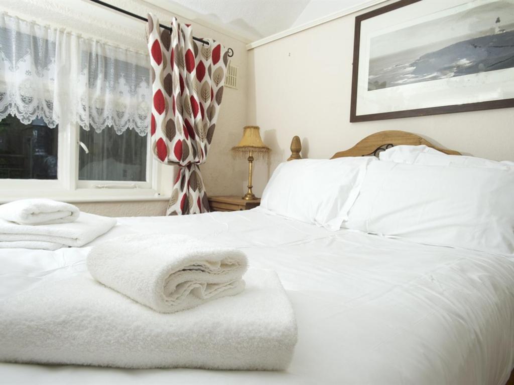 惠特比The Endeavour的卧室配有白色床和毛巾
