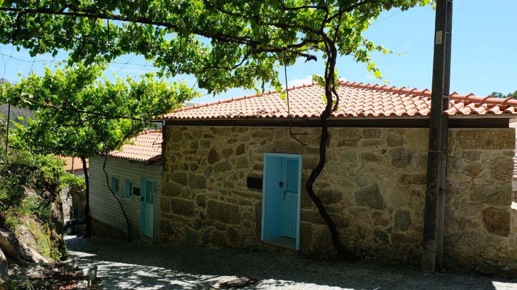 坎普-杜热雷什Casa Tritão的一座有蓝色门和一棵树的建筑