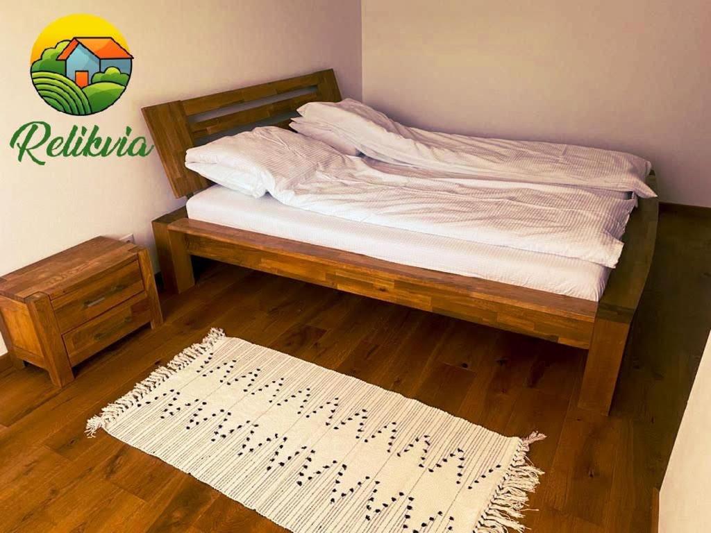 索瓦塔Relikvia的一间卧室配有一张木架床和地毯。