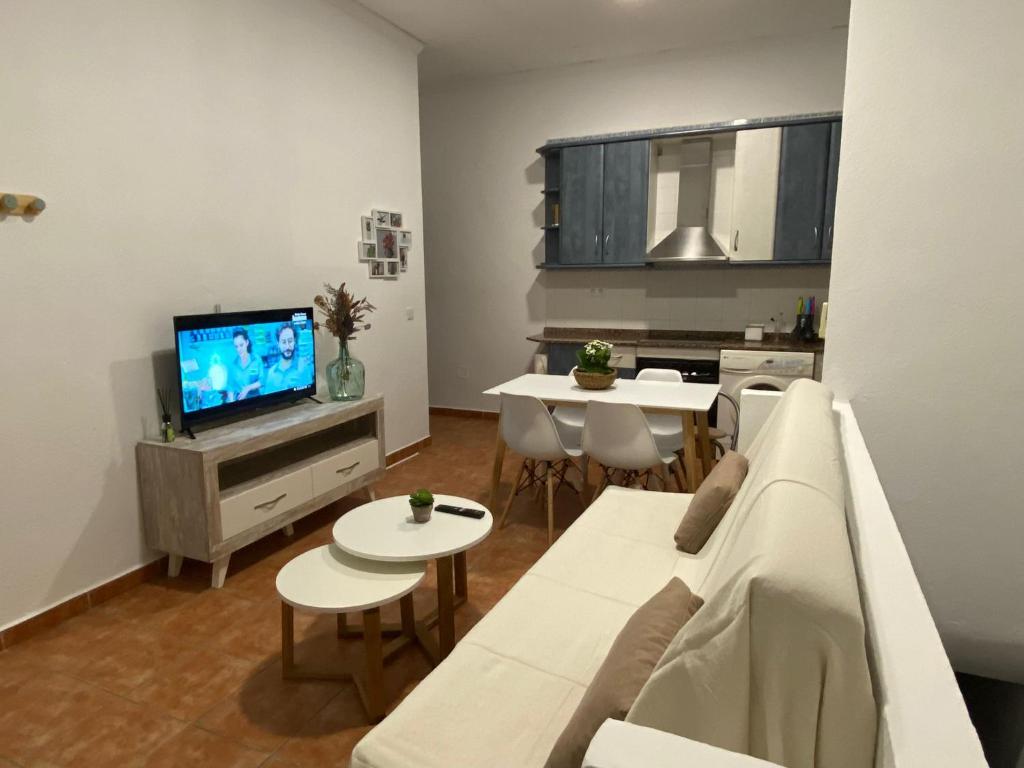 阿瓜阿马加Vivienda a pie de calle en Agua Amarga a 250 metros de la playa的客厅配有白色沙发和电视