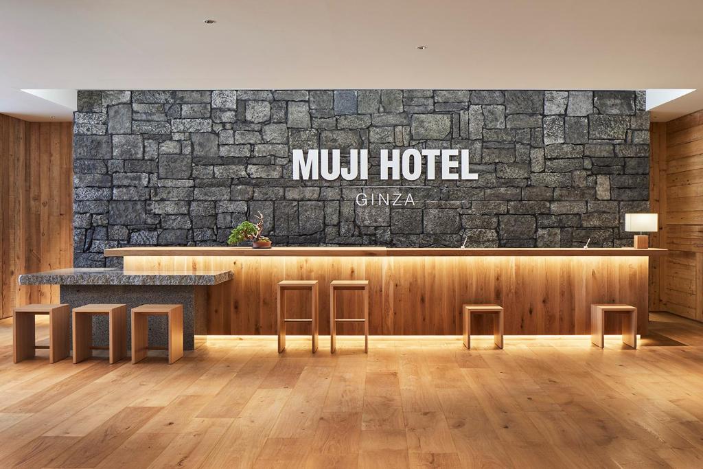 东京MUJI HOTEL GINZA的石墙的酒店大堂