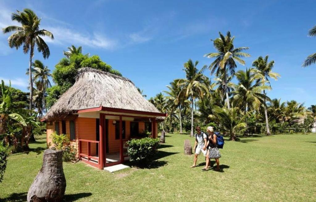 纳库拉岛Nabua Lodge的一群站在小建筑前面的人