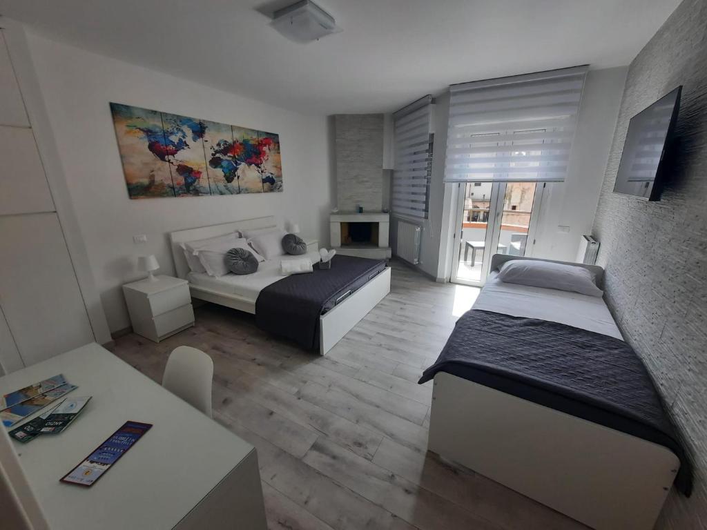 内图诺GUEST HOUSE TRA CIELO E MARE的一间带两张床和一张桌子的客厅和一间房间