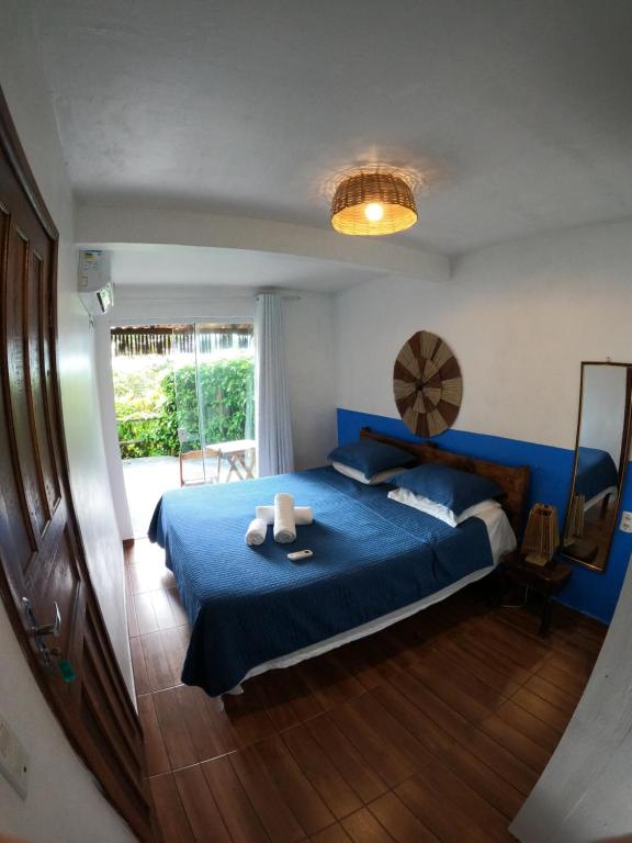 伊塔卡雷Pousada Pipe House的一间卧室设有蓝色的床和窗户。
