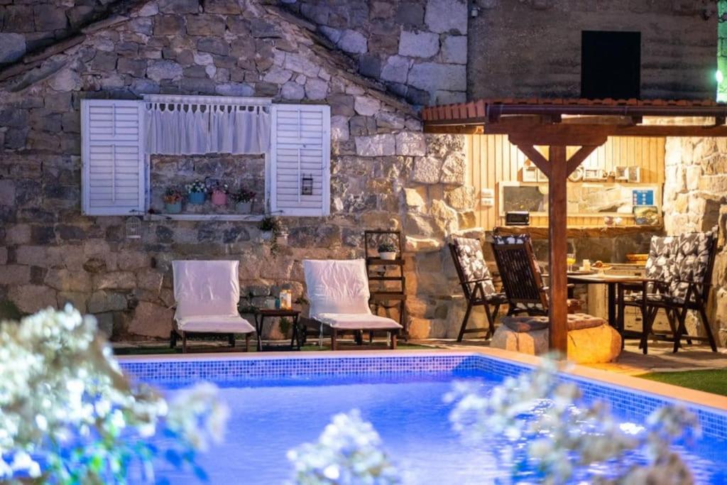 斯林Holiday House with heated pool的一个带椅子的庭院和一个游泳池