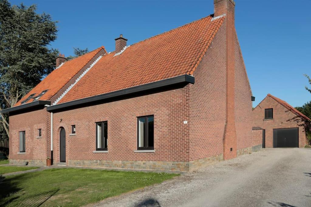 RumstHuisje van de Meentocht的一座红屋顶的大型砖砌建筑