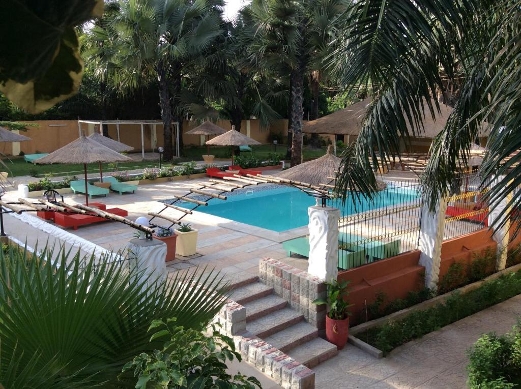 科图卡拉巴斯公寓式酒店的度假村内带楼梯和遮阳伞的游泳池
