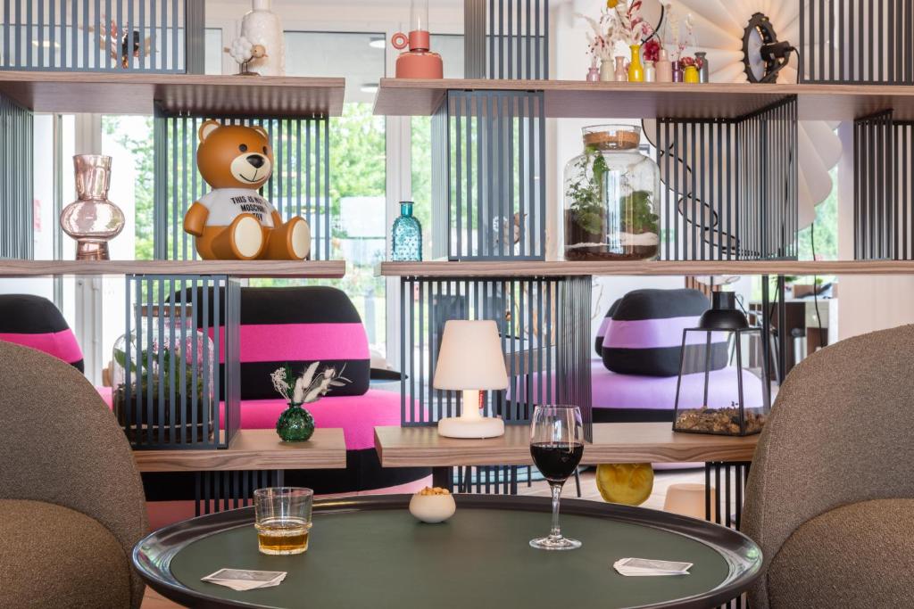 莱瑟佩瑟Hôtel Omnubo Collection的一间房间,桌子和书架上的泰迪熊