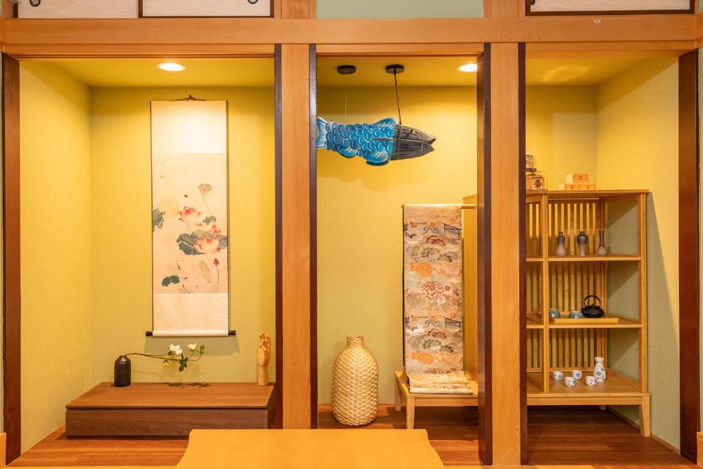 东京Japanese traditional house.Ryokan in asakusa with 2bedrooms的一间黄色墙壁、桌子和架子的房间