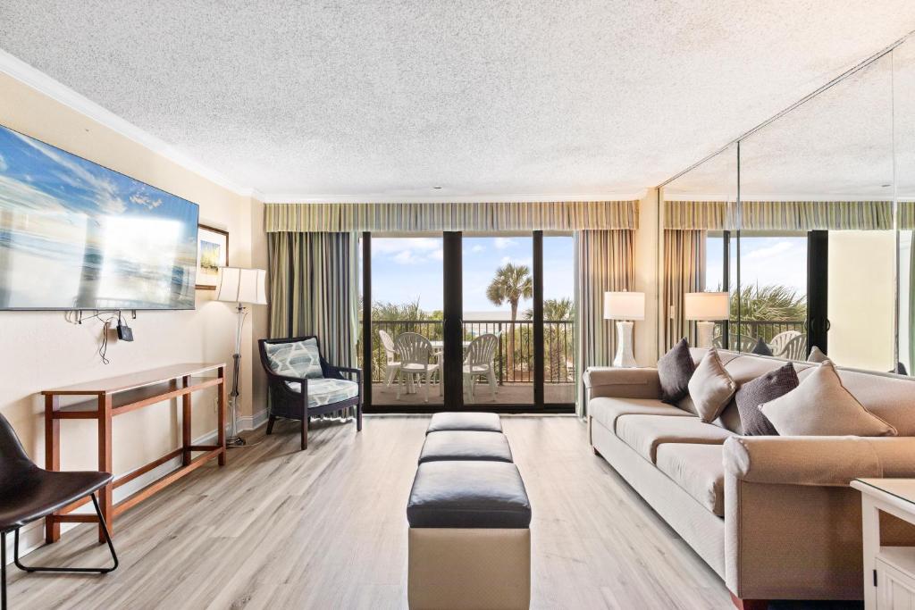 默特尔比奇2-Bedroom Carolina Dunes Condo with Private Balcony and Ocean Views的客厅配有沙发和桌子