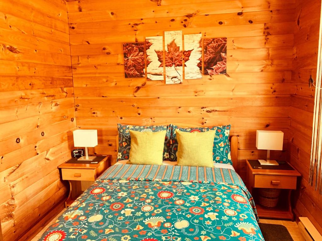 Queensport鹰谷别墅度假屋的一间卧室配有一张带2个床头柜和2盏灯的床。